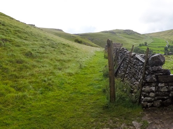 Signpost and route along stone wall